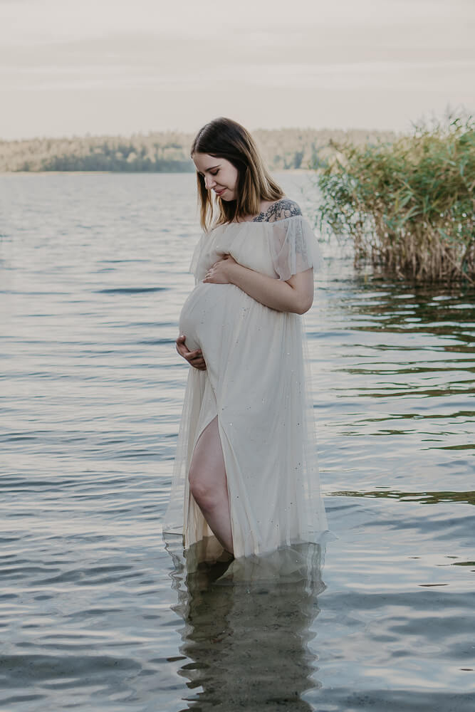 Portrait Frau lächelt und hält ihren Babybauch